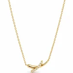 Cross-shaped necklace with a jeweled bend